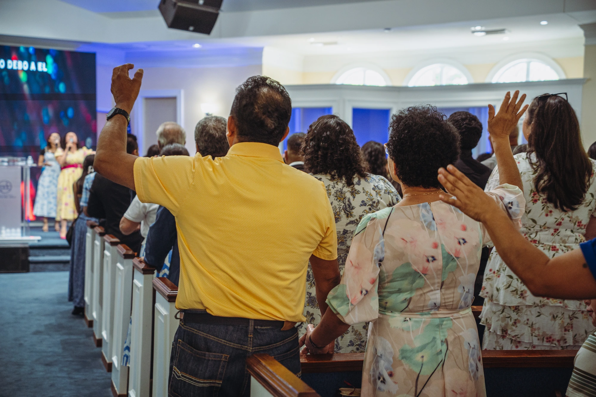 Congregación de IPDC en adoración con las manos levantadas